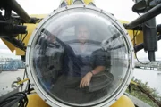 Josh Gates sits in the PC1201 submarine by the shores of Lake Michigan.