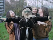 Katie, Sammy and Tammy pose with a scarecrow outside.