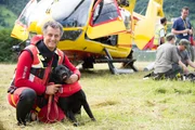 Rescue dogs with their owner by a helicopter in Italy.