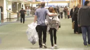 Corey and Evelin walk towards security at the airport.