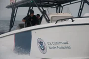 Off the Coast of Puerto Rico, USA: As a U.S. Customs and Border Patrol speed boat scans the coastline of Puerto Rico, an officer on board keeps both hands on his rifle.