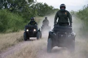 Laredo, TX: Customs and Border Protection agents patrolling the terrain near the border on ATVs.