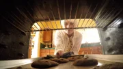 Kathryn Bishop reaches into the oven to pull out some freshly baked cookies for her guests.