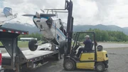 Forklifter is lifting airplane on truck