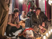 Captain Jackson (Adam Rothenberg, 2.v.l.) und Inspector Drake (Jerome Flynn, r.) gehen davon aus, dass der Hellseher Alex Le Cheyne (Jason Manford, Mitte) vergiftet worden ist. Olivia Wakefield (Georgina Rich, 2.v.r.), die mit Le Cheynes Hilfe Kontakt zu ihrem verstorbenen Ehemann aufgenommen hat, wird von Mimi Morton (Lydia Wilson, 4.v.r.) getröstet.
