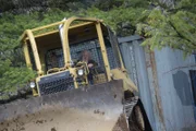 Billy Brown uses the dozer to pull Bear‚Äôs second conex container up the mountain.