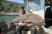 Jeremy Wade hält den Heilbutt, den er gerade gefangen hat.