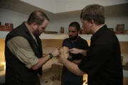 Josh Gates, Victor Mendoza, and Stanley Guenter analyze a Mayan dynastic vase at the National Museum of Archeology in Guatemala City, Guatemala.