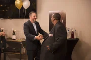 Dr. Procter and Drew smiling while shaking hands at the reveal party.