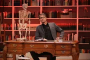Christoph Sieber sitzt an seinem Studio-Schreibtisch.