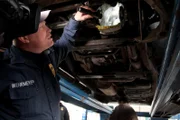 El Paso, TX: Officer Melano looking at the underside of a car that is being searched. Smugglers use many different methods to hide contraband such as marijuana and other illegal drugs.