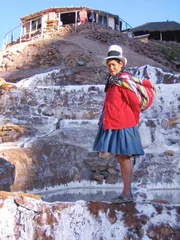 Salzbäuerin Emilia Atapaucar neben ihren Salzbecken in den Salinen von Maras, Peru