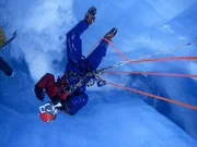 A climbing cameraman on a rope.