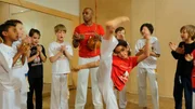 Die 7-jährige Tais hat ein Hobby, bei dem sie gleich drei Sachen können muss: turnen, kämpfen und Musik machen. Tais macht Capoeira. Das ist ein Kampftanz aus Brasilien. Damit tritt sie auf der Sesamstraßen-Bühne auf.