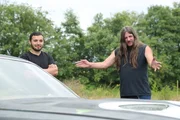 Butch is admiring the Cuda while Carlos watches.