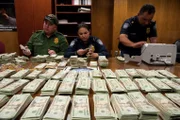 El Paso, TX: Two officers and an agent counting a large sum of confiscated cash. This cash seizure will put a dent in the powers of the cartel or gang of smugglers. The Border Protection agents remain alert for attempts to conduct illegal smuggling.