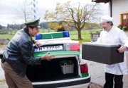 Staller (Helmfried von Lüttichau, links) lässt sich vom Koch des Gasthofs "Ludwig" Erwin Sauer (Karl Fred Müller) das Essen in den Kofferraum stellen.