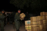 Rio Grande City, Texas, USA: Boder Patrol Agents stacking up the bundles of marijuana that they found in a house.