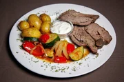 Die Hauptspeise: Gegrillte Lammkeule mit mediterranem Gemüse, Kartoffeln und Kräuterquark.