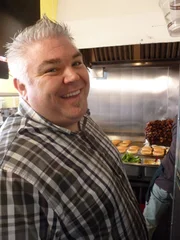 Todd smiling at Red Mill Burger.