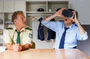 Hubert (Christian Tramitz, l.) sieht skeptisch zu, wie Staller (Helmfried von Lüttichau, r.) die Virtual-Reality-Brille testet.