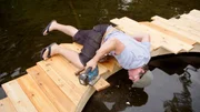 Designer Andrew Buckles uses a jigsaw to trim away the excess decking that overhangs the circular opening for the Swimming Pool Dock's fiberglass tub, as seen on Built For The Weekend.