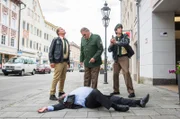 Vor den Augen von Girwidz (Michael Brandner, M.), Hubert (christian Tramitz, l.) und Staller (Helmfried von Lüttichau, r.) stürzt der Bürgermeister (Komparse) aus dem Fenster.