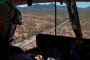 Nogales, AZ: An agent inside a flying helicopter. Helicopters can be used to direct other agents to locations where smugglers are hiding.