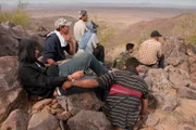 Nogales, AZ: Handcuffed men sitting on a hill. Migrants are often misled about the length of the walk from one city to another. With the difficult desert terrain and lack of supplies, this groupÕs outcome could have been grim.