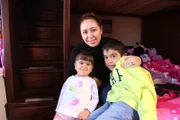 Laisha Marquez with her mother Gloria Escobedo and brother Alexander Marquez sitting on the bed.