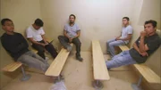 Nogales, AZ: Five apprehended men sitting in a holding cell.