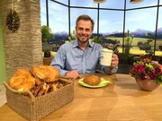 Moderator Michael Sporer mit Croissant und Bierkrug.