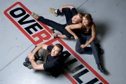 Designer Chip Foose with Co-hosts Courtney Hansen and Chris Jacobs on top of the Overhaulin' logo.