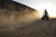 SAN DIEGO, CA, USA: A border patrol agent on an ATV surveys the international boundary that separates San Diego from Tijuana. This San Ysidro border crossing is the busiest in the world, with over 40 million people entering the U.S. through this port in 2005 alone.