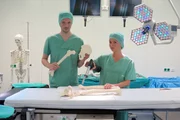 Die „"Xenius"“-Moderatoren Emilie und Adrian im OP-Saal mit einem Hüft-Präparat