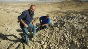 Wide shot, Dave and Jason (L-R) smiling with gold detectors