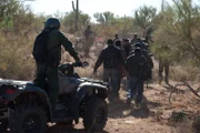 Nogales, AZ: Agents on ATVs leading away apprehended men. If any of the men were smuggling drugs such as marijuana, it will be seized and given to the  Drug Enforcement Administration or DEA.