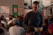 Nogales, Mexcio: Father Sean Carroll giving food to people after his service. A thousand people crowd into the center each week, to get help before moving on.