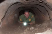 Nogales, AZ: An agent looking through an underground tunnel. Claustrophobic tunnels like these could be infested with cockroaches and other parasites.