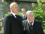 Natürlich geht auf Joans Beerdigung allerlei schief. Und als dann auch noch Sargträger Harry zusammenbricht, müssen Doc Martin (Martin Clunes, l.) und Bert (Ian McNeice, r.) erste Hilfe leisten.