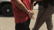 Brownsville, TX, USA: A handcuffed man is led away by an agent.