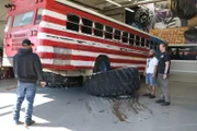 Monster bus sitting on giant monster truck wheels.