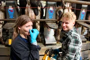 Jana (l) am Melkkarussell mit Annelies Westert, der Tochter des Milchbauern.