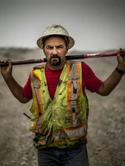 Dave Turin holding a shovel over his shoulders.