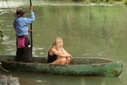 Andrea sitting in a boat with her arms crossed over her knees in Belize.