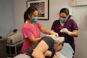 Dr. Sandra Lee and Medical Assistant Val perform surgery to remove cysts from Brandon's head.