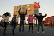 The group in front of the south of the border sign.