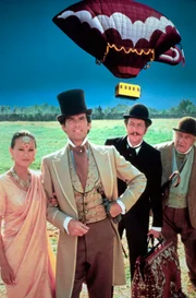 Mit Detektiv Fix (Peter Ustinov, re.) dicht auf seinen Fersen setzt Phileas Fogg (Pierce Brosnan, 2.v.l.) mit Jean Passepartout (Eric Idle, 2.v.r.) und Prinzessin Aouda (Julia Nickson) seine Reise um die Welt fort.