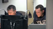 Einsatzleiter Klaus Behrend (li.) und Verhandlungsführer Martin Renner (re.) beobachten über Monitor die Situation im Gerichtssaal