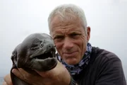 Jeremy Wade on a boat in Plymouth holding a Moray Conger Eel.